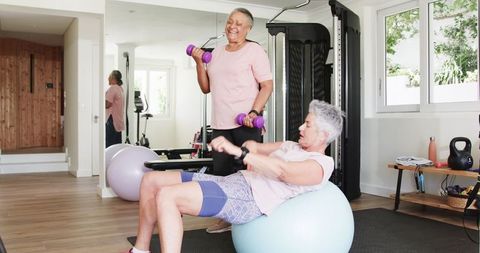 Senior Lesbian Couple Enjoying Home Workout with Dumbbells and Fitness Ball