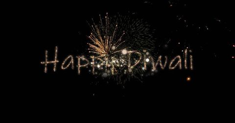 Glowing golden spark-trail happy diwali lettering with fireworks burst on black sky