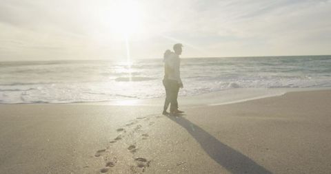 Couple Walking on Sunny Beach at Sunset with Footprints - Download Free Stock Images Pikwizard.com