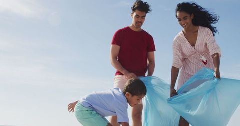 Family volunteering on beach clean-up day