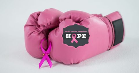 Breast cancer awareness with pink boxing gloves and ribbon symbol