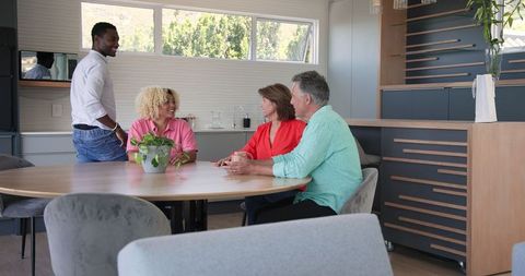 Family Gathered Around Kitchen Table Sharing Joyful Moments