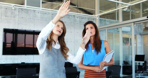 Dynamic Businesswomen Discussing Project with Gestures in Modern Office - Download Free Stock Images Pikwizard.com