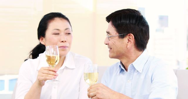 Senior Asian Couple Enjoying Glasses of White Wine Together - Download Free Stock Images Pikwizard.com