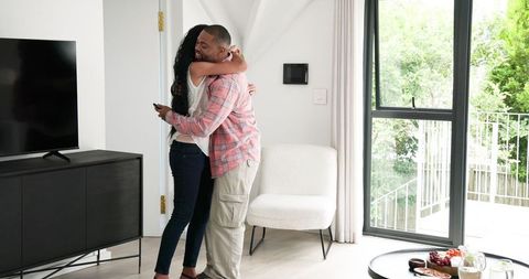 Joyful couple celebrating engagement with selfie at home