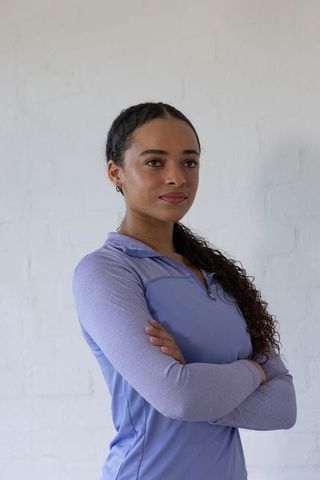 Confident african american woman standing arms crossed in lilac athletic top