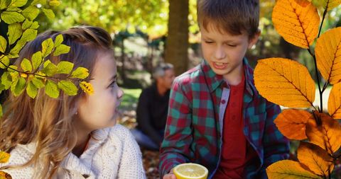 Children enjoying autumn outdoor play surrounded by vibrant leaves