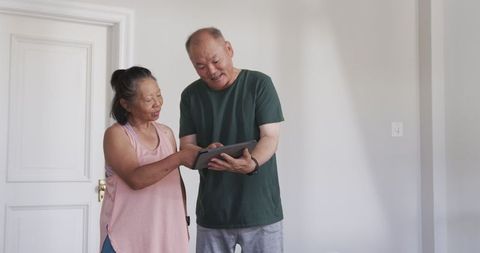 Elderly Couple Enjoying Time with Tablet at Home