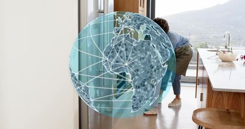 Parent and child interacting with augmented reality globe in bright modern kitchen