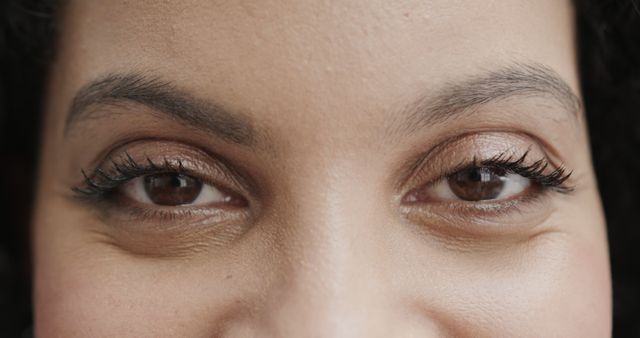 Close up of eyes of happy, smiling biracial female doctor. Medical services, wellbeing and healthcare, unaltered.