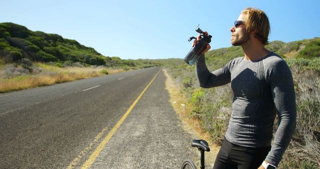 Cyclist Taking a Break for Hydration on Open Road - Download Free Stock Images Pikwizard.com