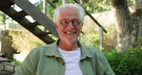 Senior Man Enjoying Peaceful Moment in Lush Home Garden