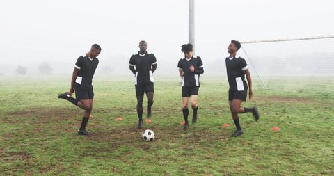 Young Soccer Team Training on Foggy Morning Field