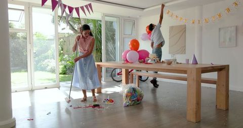 Family Cleaning Up Birthday Party with Teamwork Inside Home