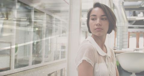 Businesswoman Contemplating Office with Reflected Cityscape