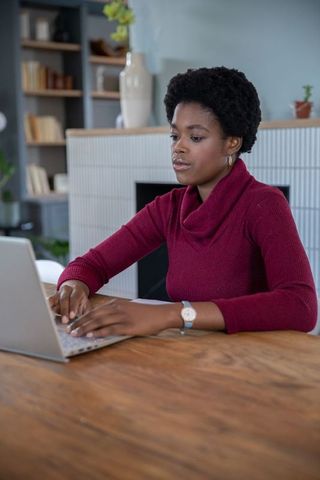 Focused Woman Working on Laptop in Cozy Home Office