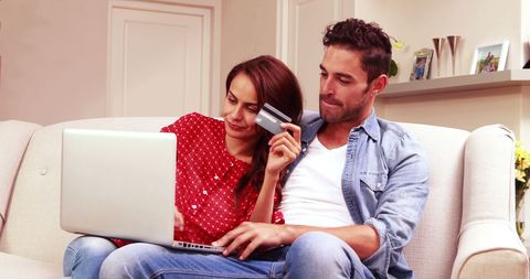 Couple Enjoying Online Shopping With Laptop on Couch