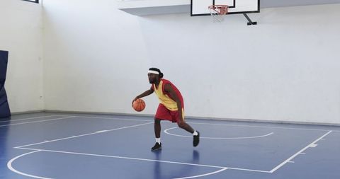 Athlete Dribbling Basketball in Indoor Gymnasium