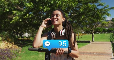 Smiling Woman Talking on Phone and Holding Electric Scooter Outdoors