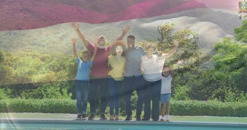 Multigenerational family raising arms and hugging poolside with flag overlay