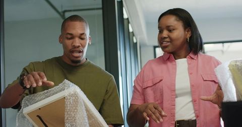 African american couple unpacking framed art together in bright modern interior