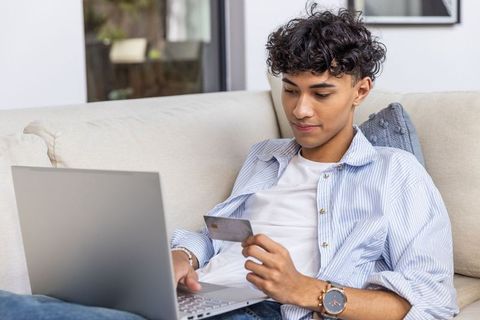 Young man shopping online comfortably from home