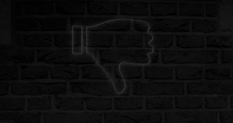 Glowing Neon Dislike Icon on Dark Brick Wall