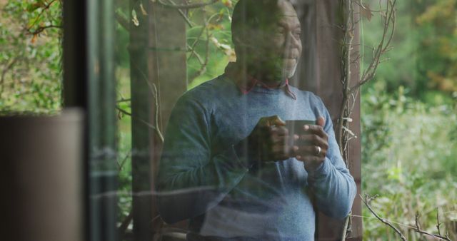 Senior Man Reflecting While Holding Coffee Mug and Looking Through Window - Download Free Stock Images Pikwizard.com