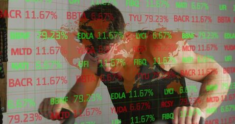Mid-adult man pushing through high-intensity cardio bike workout with stock ticker overlay