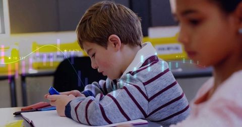 Boy engaging with technology in classroom with digital chart overlay