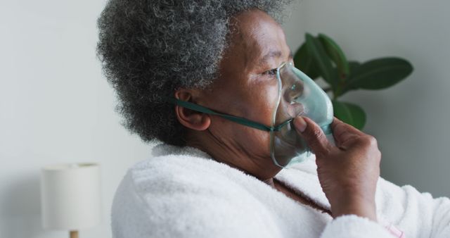 Elderly woman wearing an oxygen mask, looking concerned. Suggests medical care or respiratory issues. Useful for health-related articles, healthcare services, senior care facilities, and respiratory illness awareness campaigns.