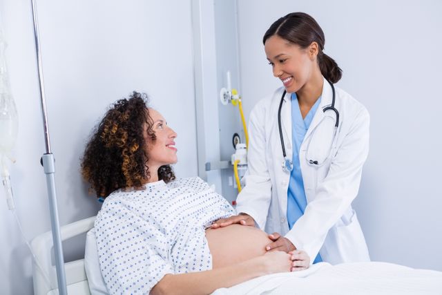 In this scene, a doctor is examining a happy pregnant woman in a hospital ward. The doctor and the patient are smiling, symbolizing positive healthcare experience. Ideal for use in healthcare-related content, maternity care articles, medical brochures, and advertisements for pregnancy services.