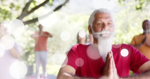 Seniors Practicing Outdoor Yoga Amid Light Decor and Lush Garden