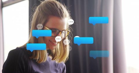 Smiling blonde woman reading messages with floating blue chat bubbles