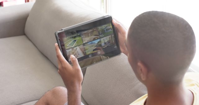 Person Using Tablet for Home Security Monitoring on Sofa - Download Free Stock Images Pikwizard.com