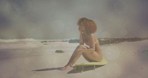 Woman Relaxing on Beach with Surfboard in Vibrant Sunrise