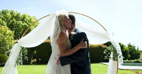 Bride and groom with diverse guests at outdoor ceremony