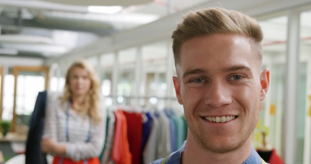 Man Smiling in Modern Office with Colleague in Background - Download Free Stock Images Pikwizard.com