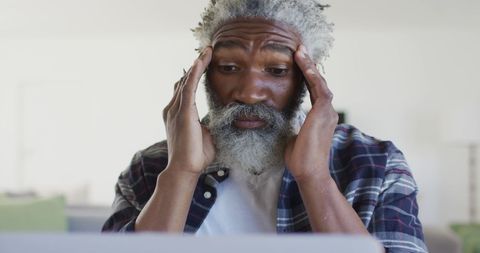 Mature Man Stressing over Work at Home with Laptop