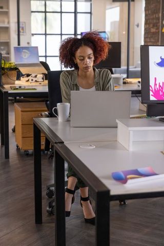 Focused Employee Using Laptop in Modern Open-Plan Office