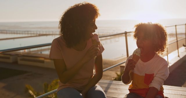 Mother and Child Sharing Ice Cream on Beach Boardwalk at Sunset - Download Free Stock Images Pikwizard.com