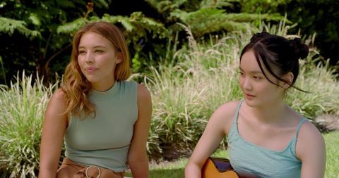 Diverse Female Friends Enjoying Sunny Garden with Guitar