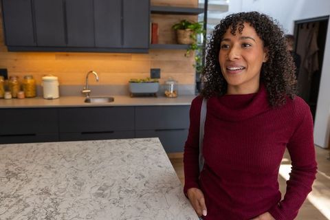 Woman Leaning on Modern Marble Kitchen Island with Natural Light