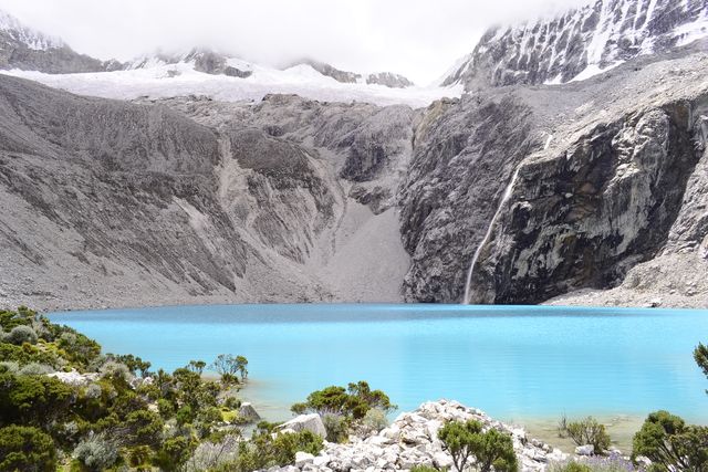Serene blue glacial lake set in Andean mountains, showcasing pristine water and rugged terrain. Perfect for travel brochures, nature documentaries, adventure travel blogs, and environmental awareness campaigns. Exemplifies tranquility and untouched wilderness, ideal for promoting outdoor activities and eco-tourism.