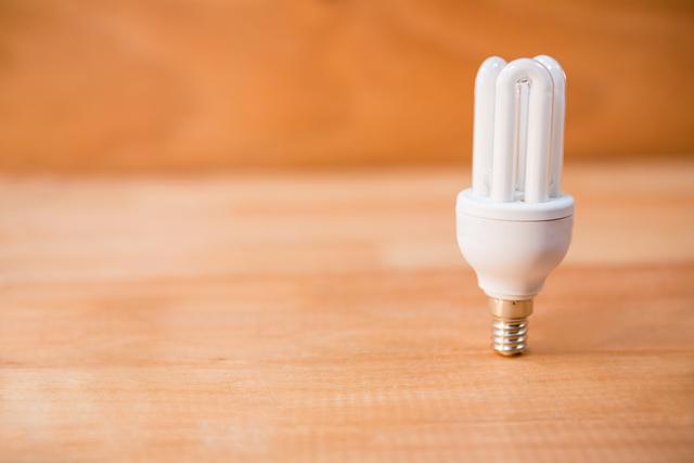 Energy saving bulb on a wooden floor - Download Free Stock Photos Pikwizard.com