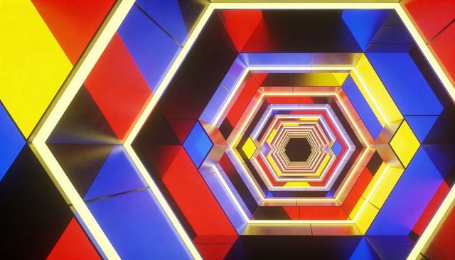 Hexagonal neon tunnel receding into dark void with colorful led frames and reflections