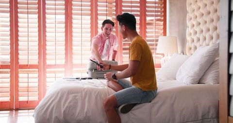 Happy Male Couple Packing Suitcase for Relaxing Getaway