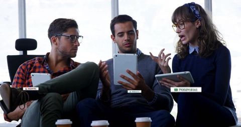 Young Coworkers Collaborating with Tablets and Coffee in Modern Office