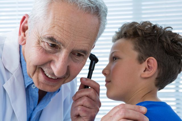 Doctor and patient using otoscope in clinic