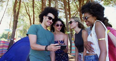 Young Adults Sharing Memories During Camping Trip in Woods